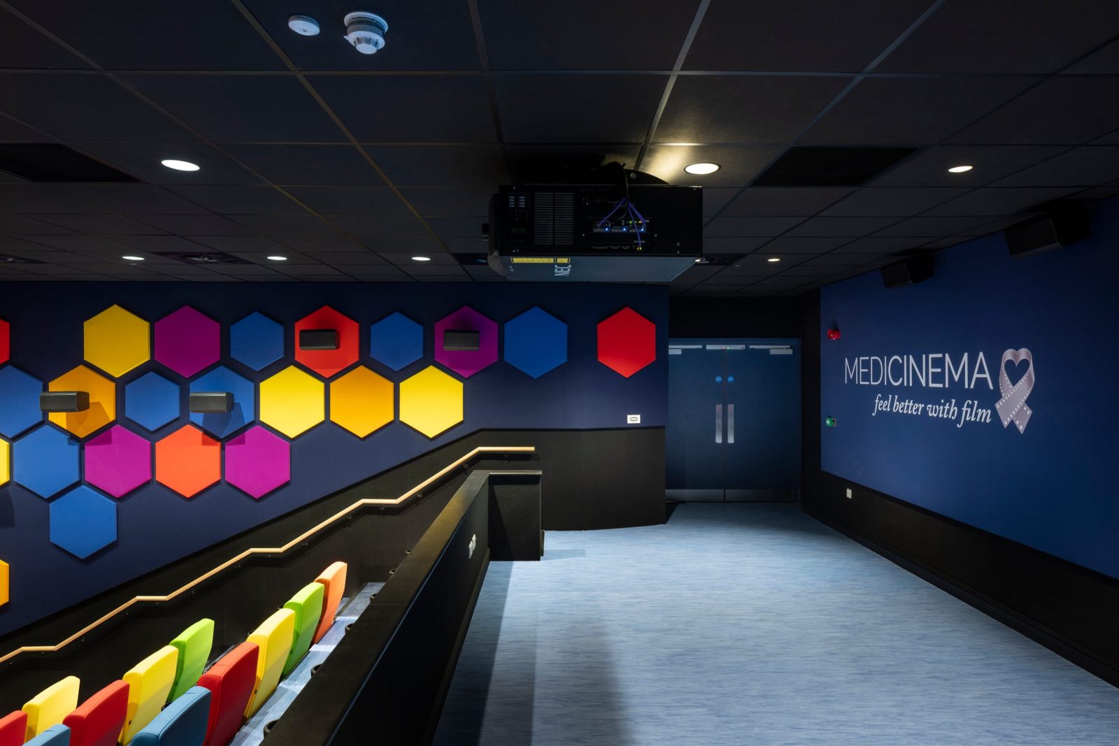 The open floor at the front of the auditorium, beside the entrance doors