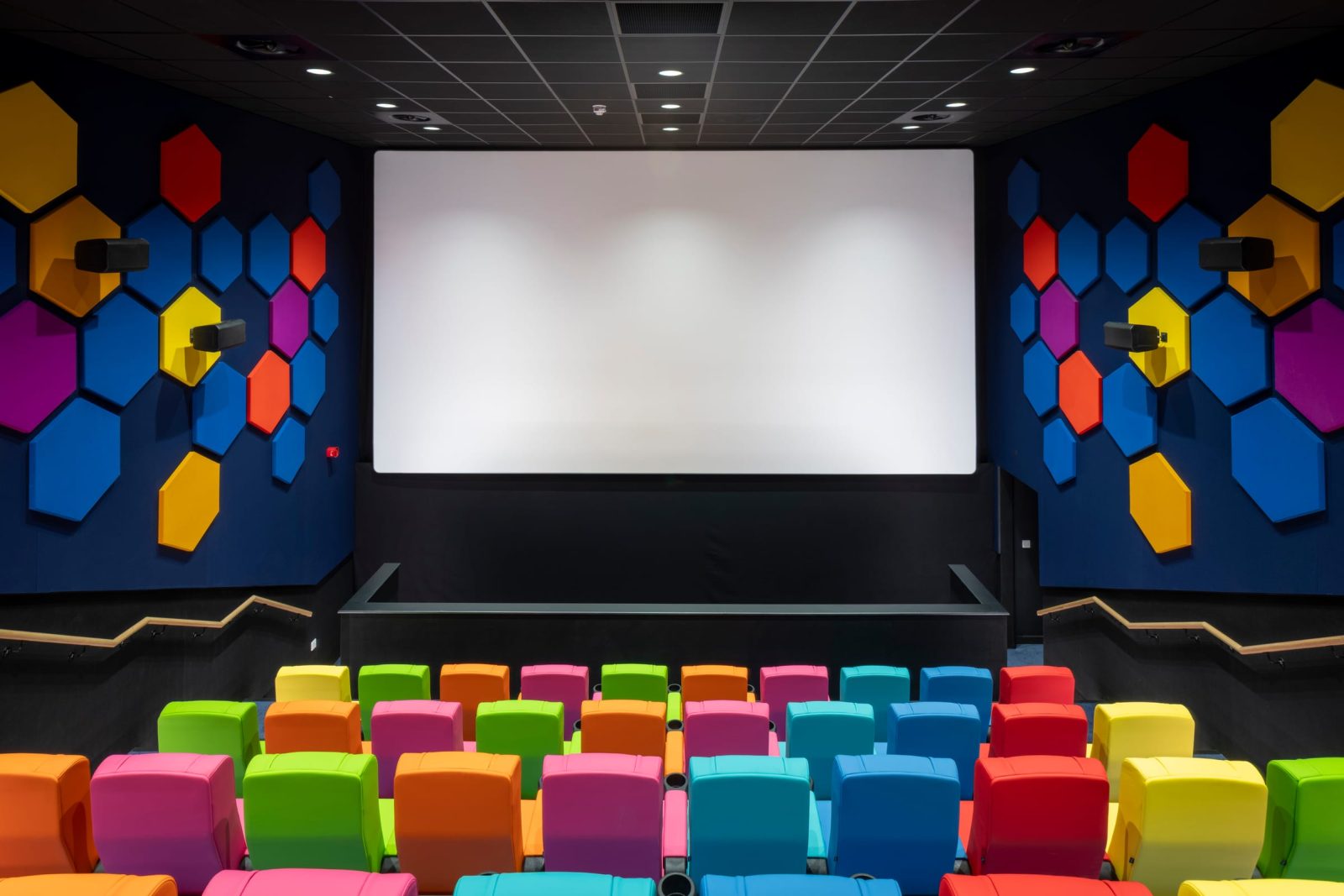 The cinema screen and front rows, with hexagonal acoustic panels on the side walls